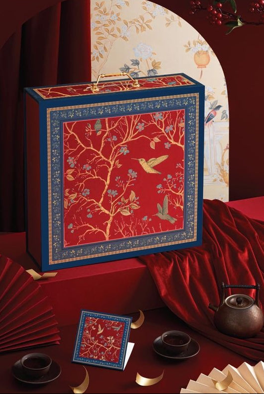 Decorative box with floral and bird design on a red background, featuring the brand 'tetta'.